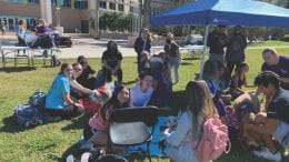 NSU students sit in the Library Quad petting dogs at Yappy Hour with CAT.